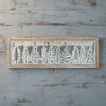 Decorative sign with Christmas trees and text on a wooden background