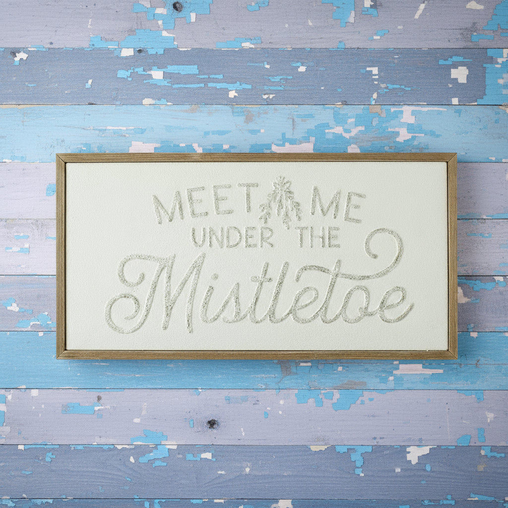 Decorative sign with 'Meet Me Under the Mistletoe' text on a white background